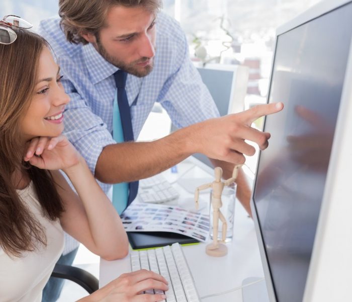 Man pointing something to his partner on screen in creative office